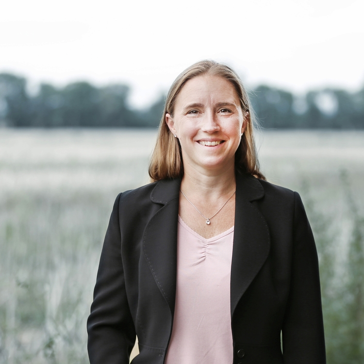 Portraitfoto einer Person vor einem Feld